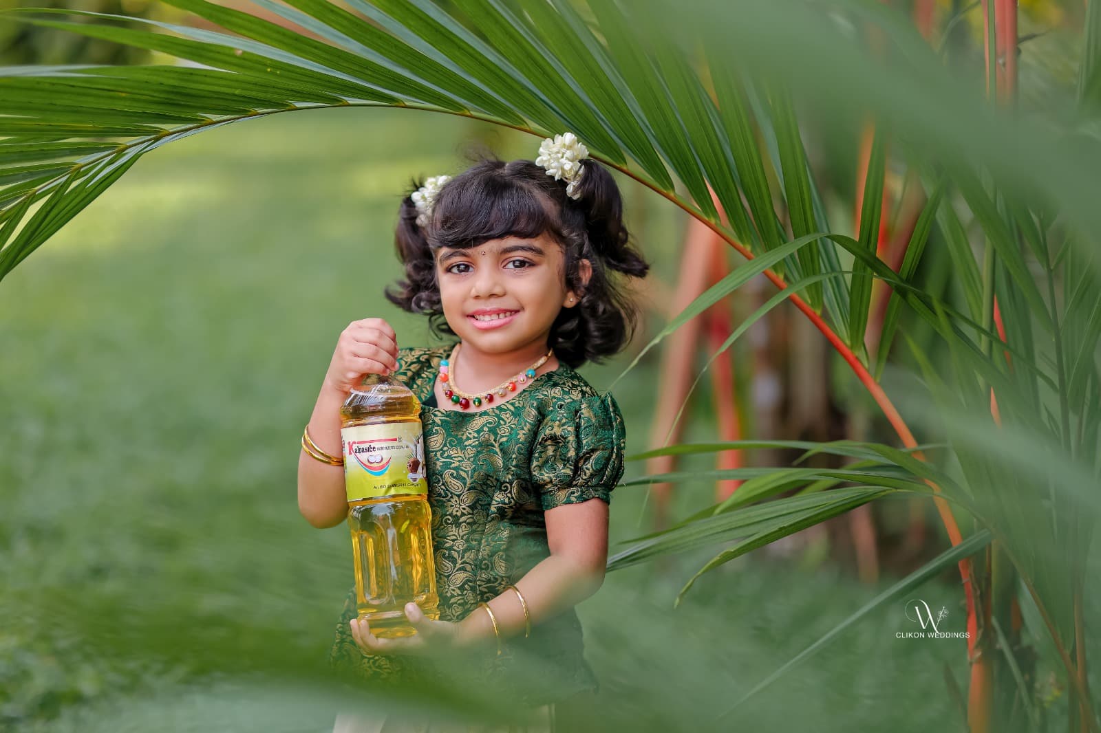 A Kalpasree bottle among the palms